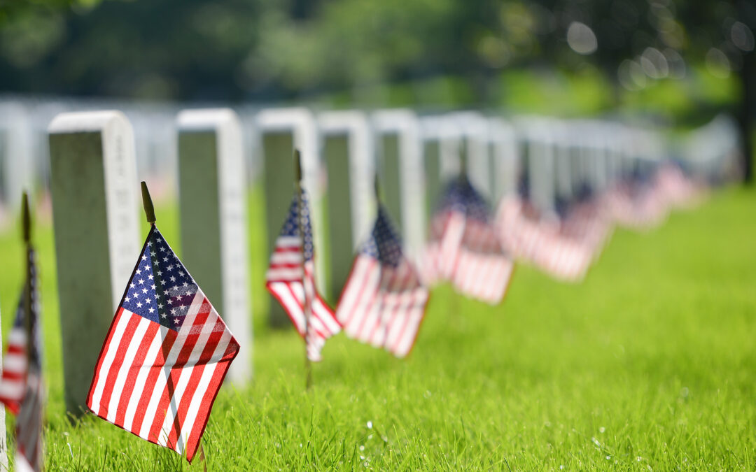 United States flags at headstones in cemetery